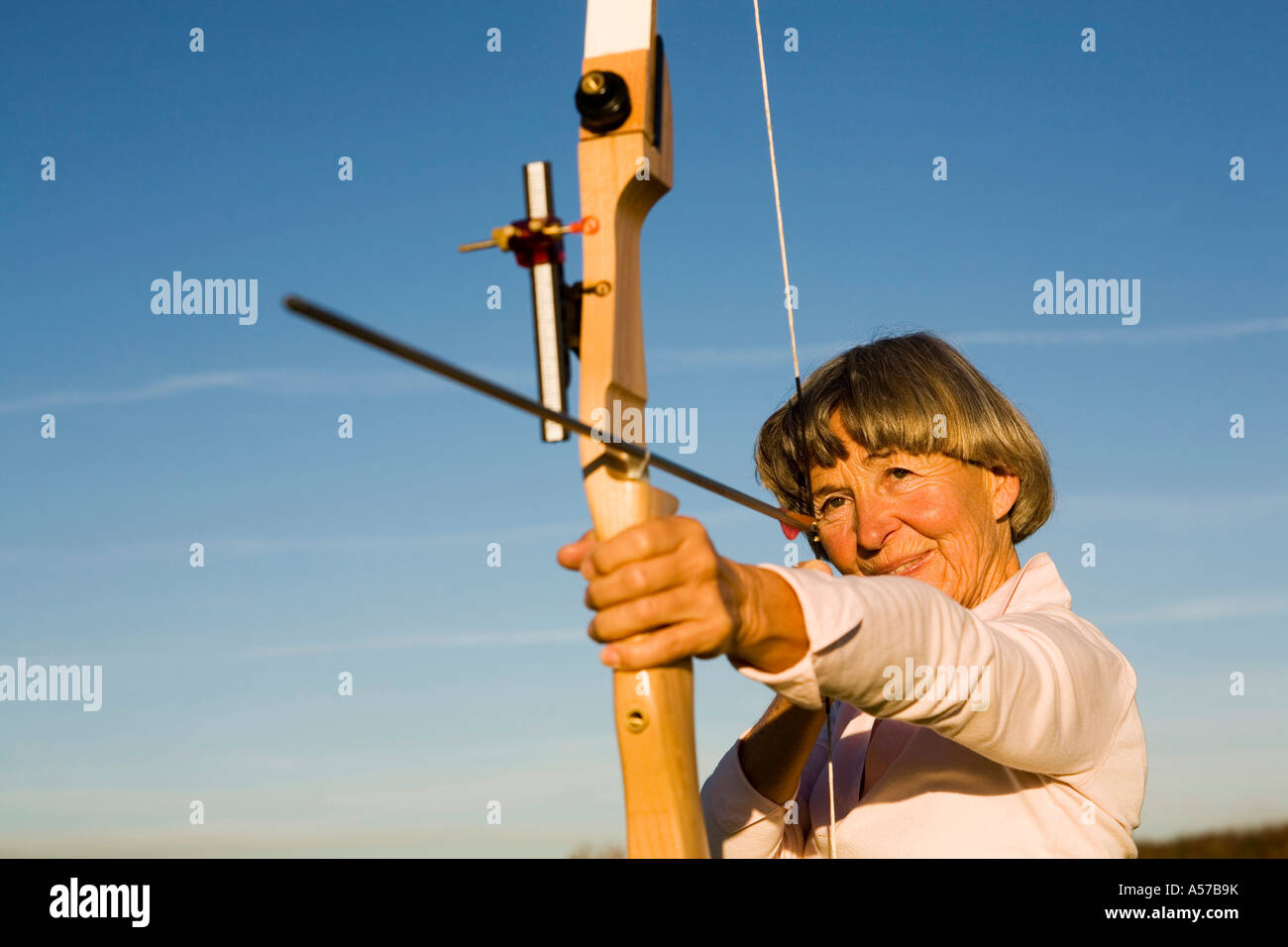 Ältere Erwachsene Frau mit Pfeil und Bogen Stockfoto