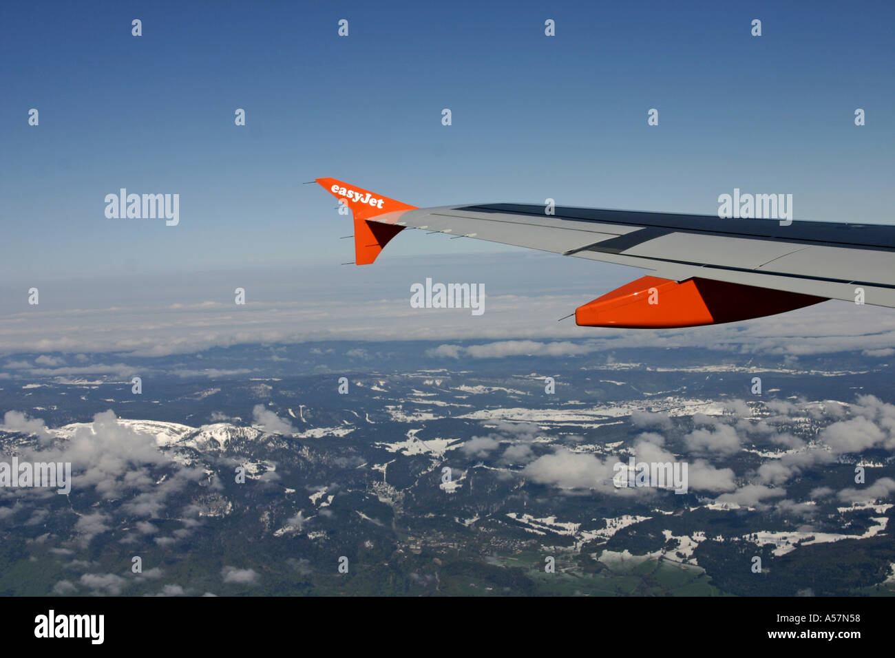 Luftbild von Easyjet Flugzeugflügel und Flügelspitze mit schneebedeckten Berge Himmel und Wolken Stockfoto