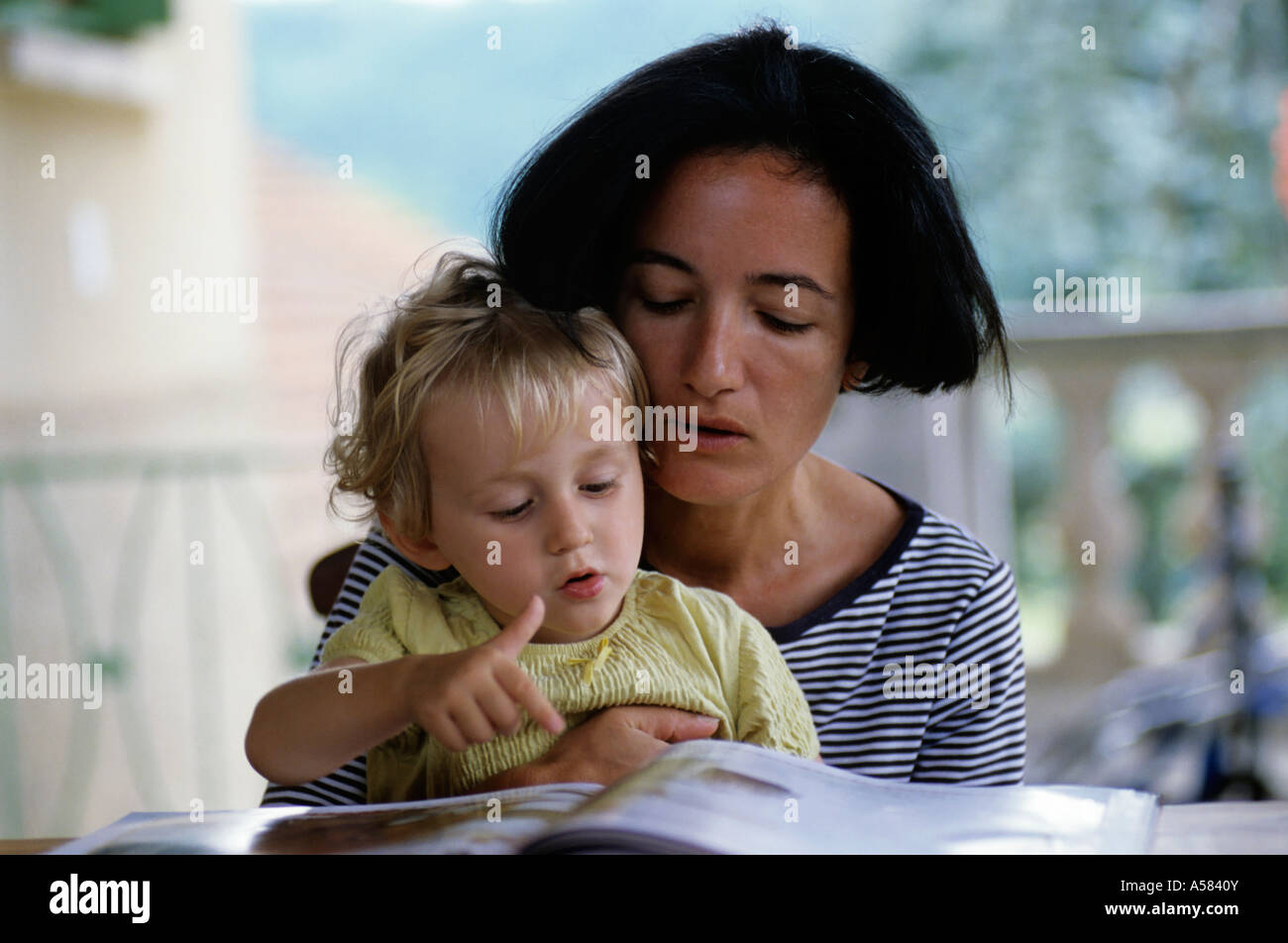 Mutter und ihrer kleinen Tochter zusammen ein Kinderbuch lesen Stockfoto
