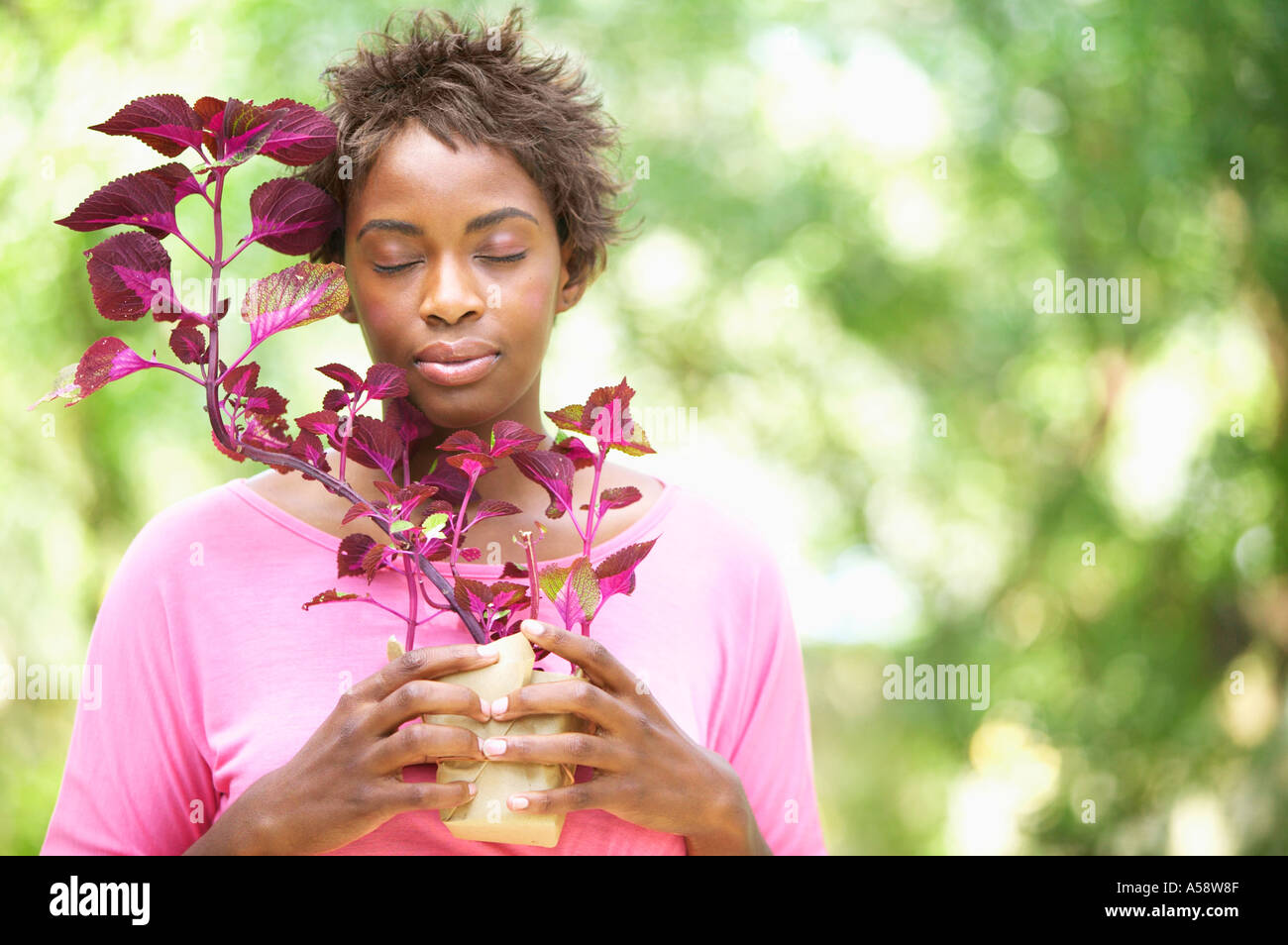 Frau, die Pflanze mit Augen geschlossen Stockfoto