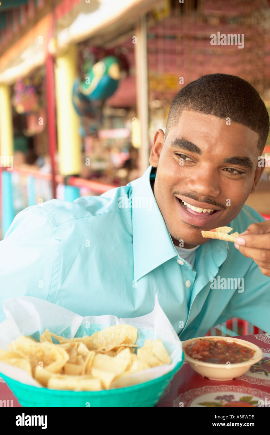 Mann isst Chips und salsa Stockfoto