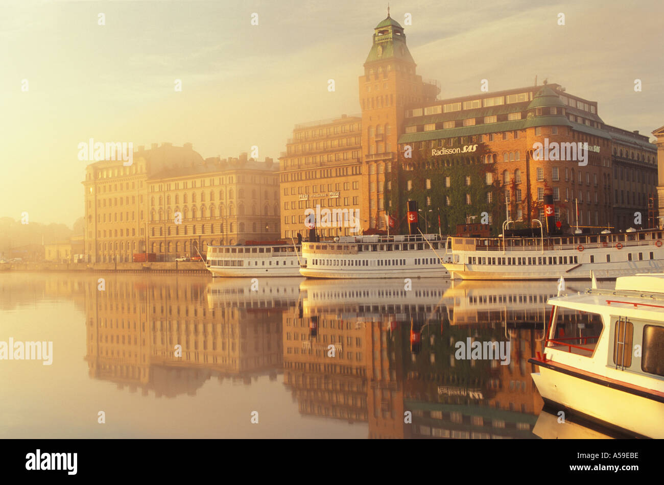 Fähren am Nybroviken mit SAS Radisson Hotel bei Sonnenaufgang in Stockholm verankert Stockfoto
