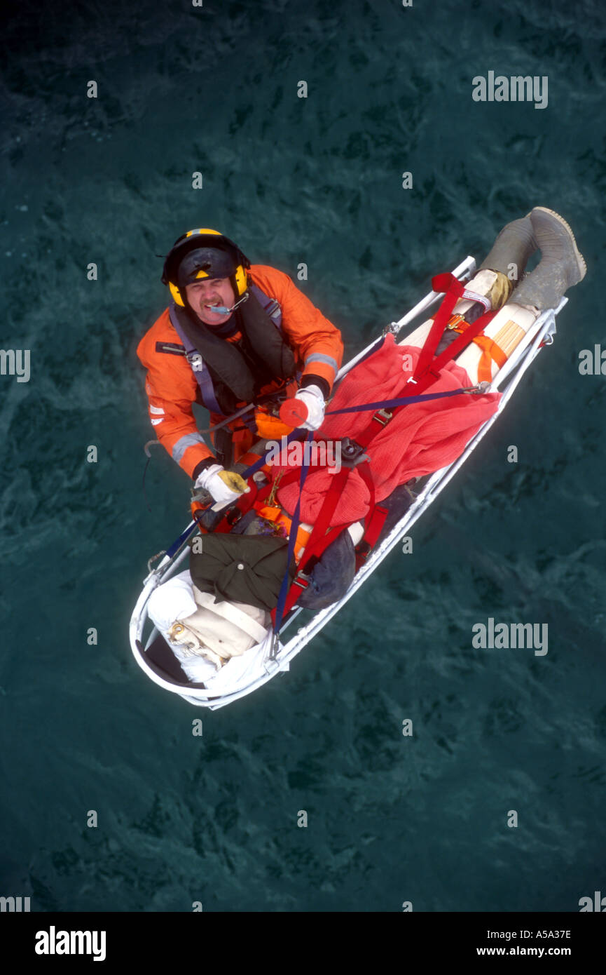 Küstenwache Winde Mann ist von der Such- und Rettungshubschrauber gesenkt. Stockfoto