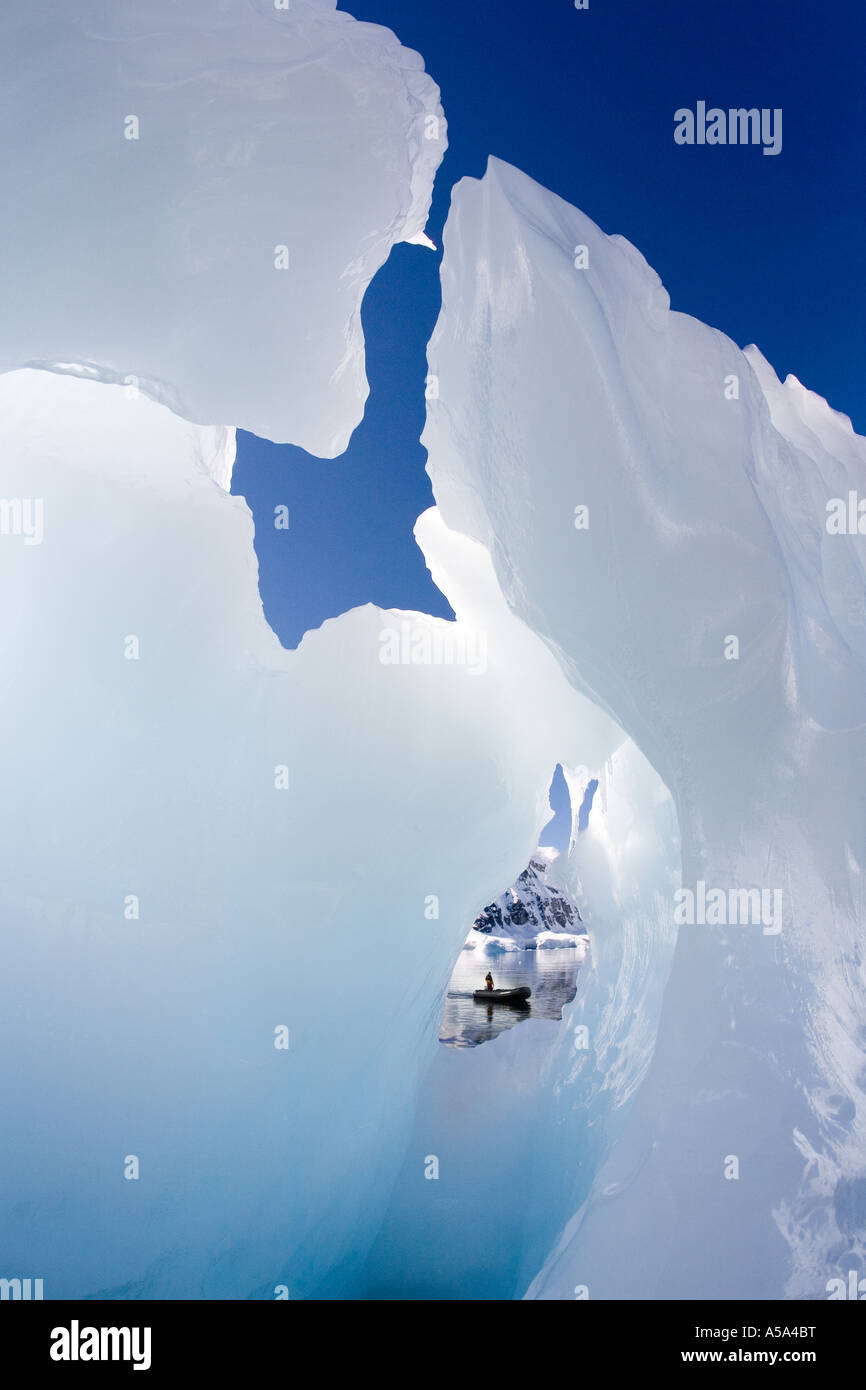 Zodiac Handwerk durch Löcher in einem Eisberg in Cuverville Bay auf der antarktischen Halbinsel betrachtet Stockfoto