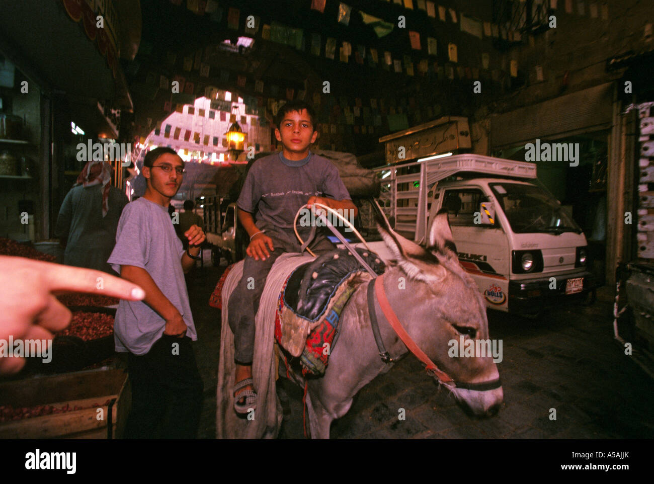 Ein Junge, Reiten, ein Esel in einem Souk oder Markt in Aleppo Syrien Stockfoto