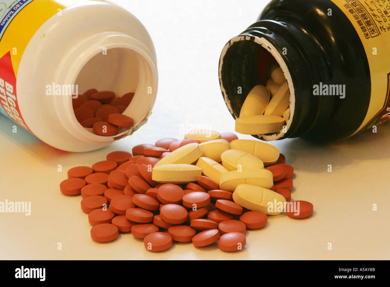 Generische Multi Vitamin Tabletten Pillen Kapseln Auslaufen von von zwei  2-Medizin-Flaschen auf weißem Hintergrund Stockfotografie - Alamy