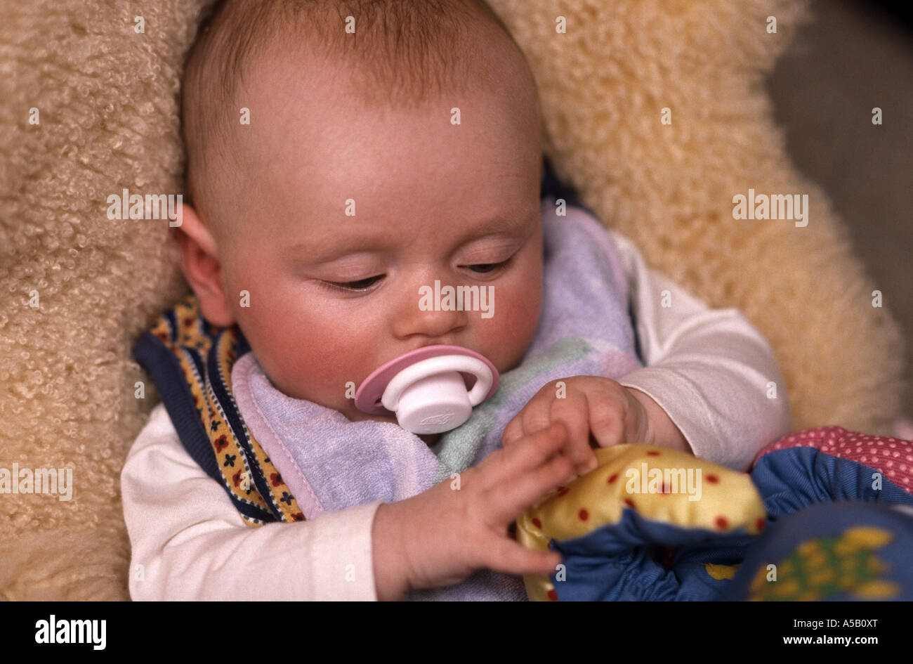 vier Monate alten Jungen mit Schwerpunkt auf seinen Händen Stockfoto