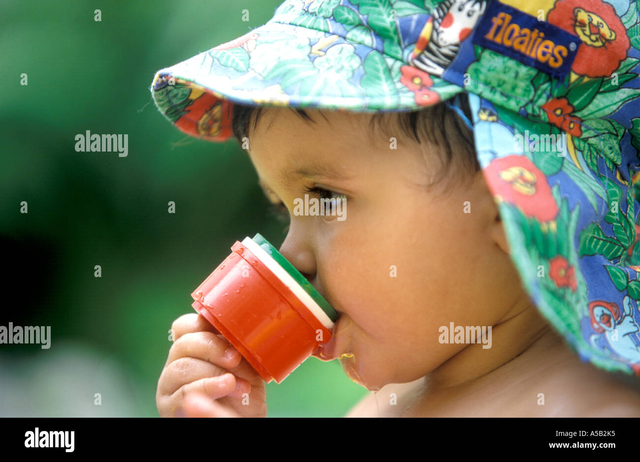 Toddel mit Suncap trinken aus einer Tasse Stockfoto
