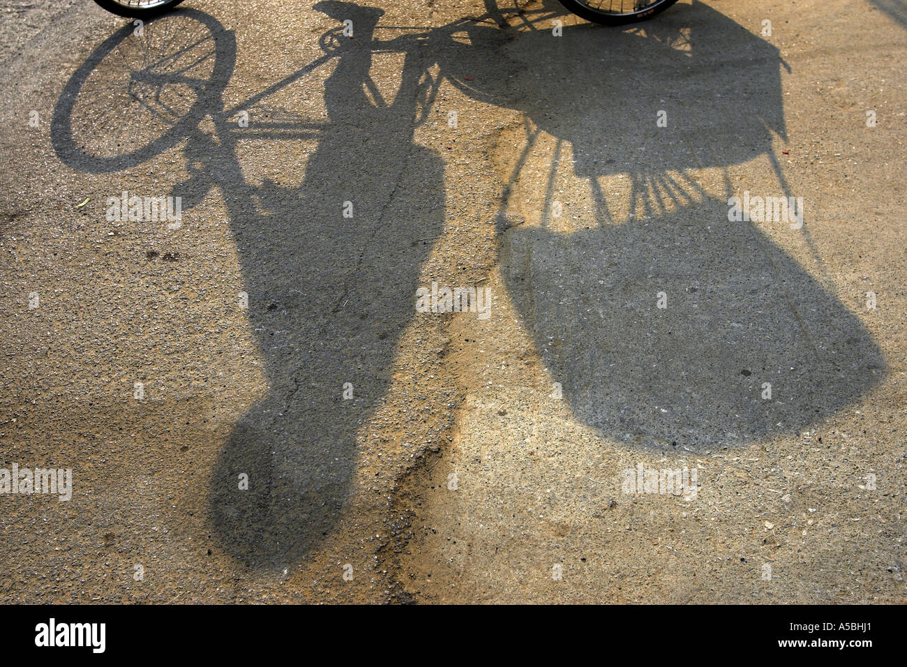 Schatten Sie auf der Straße von Fahrer und Fahrrad-Rikscha Kanchanaburi Thailand Stockfoto