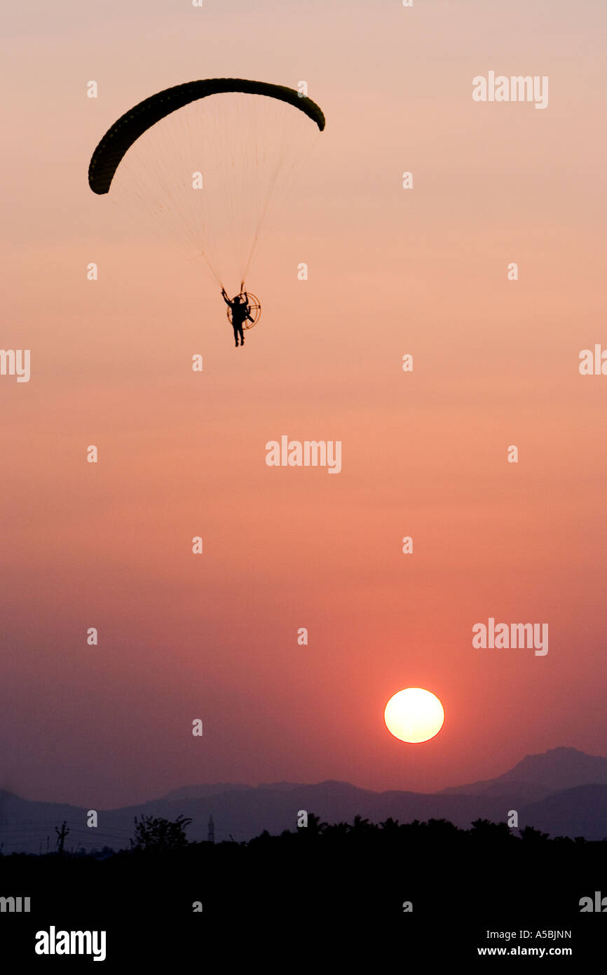 Silhouette Profil des Mannes mit einem Motorschirm in Südindien in den Abendstunden Sonne im Hintergrund Einstellung Stockfoto