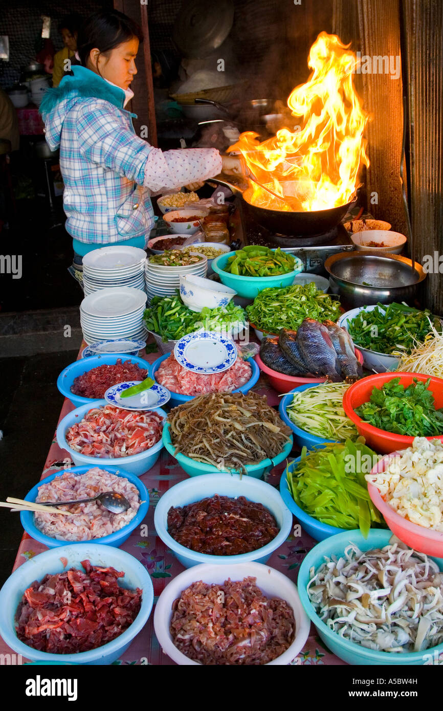 Flammen aus einem Wok frisch zubereitete Speisen am Markt Menghai China Xishuangbanna Stockfoto