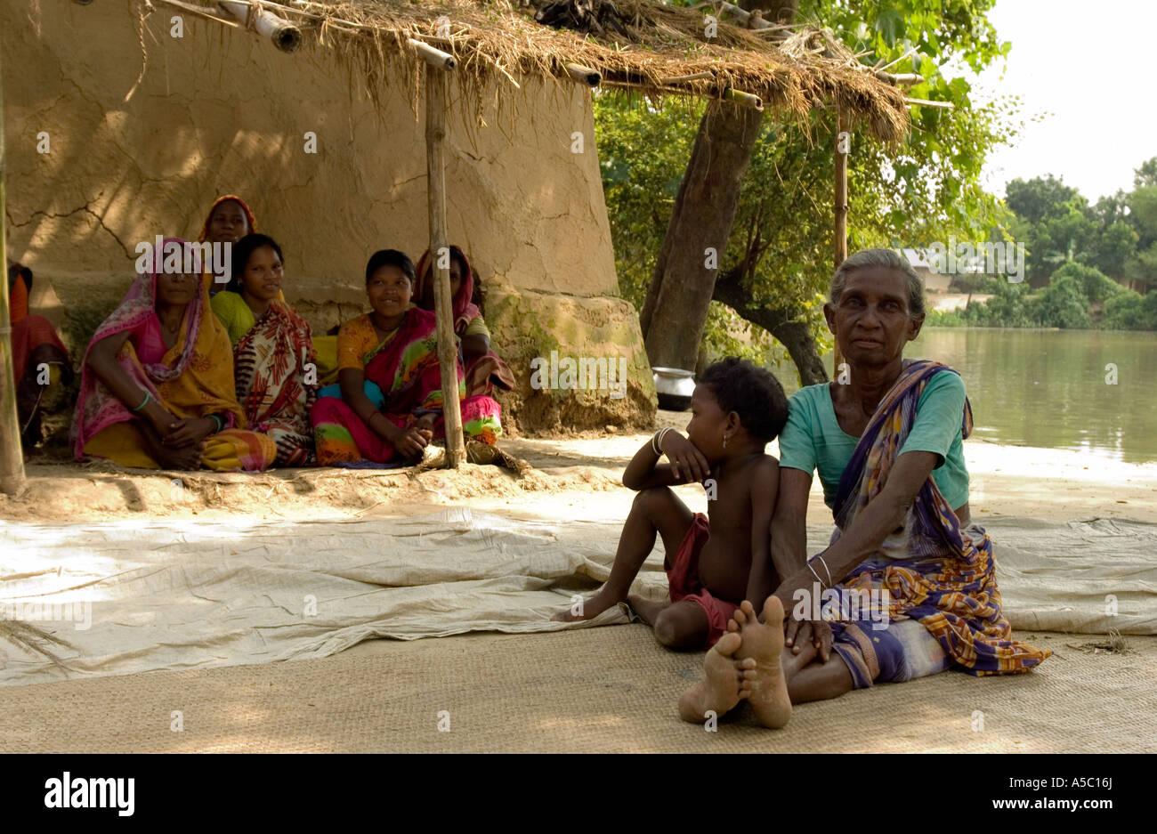 Großmutter mit Kind sitzt unter Schutz in ländlichen Dorf in Bangladesch Stockfoto