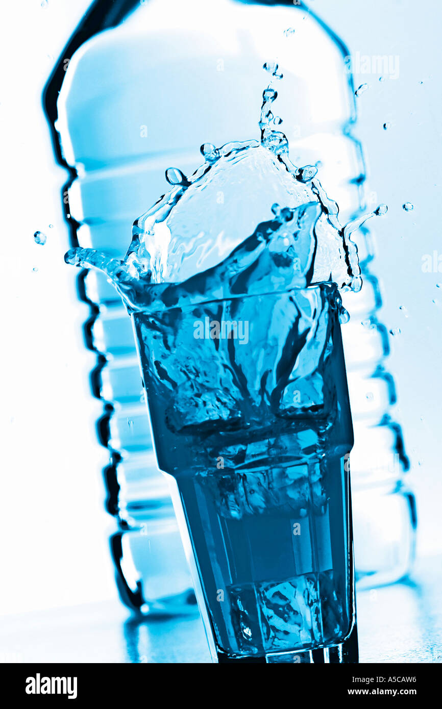 Glas Wasser vor einer Flasche Spritzen Stockfoto