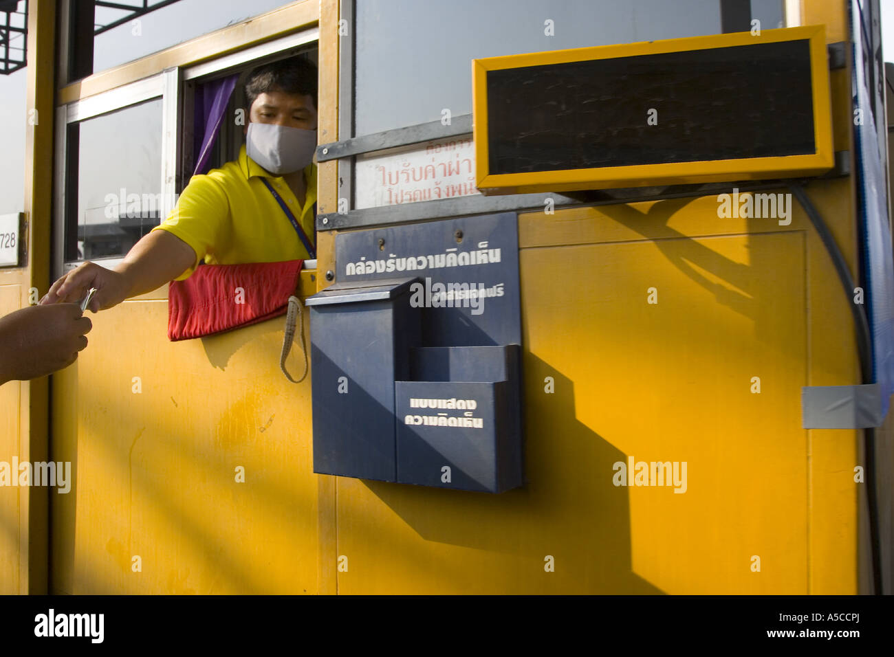 Mautstelle Fenster Ticket Betreiber in Bangkok Stadt, in Thailand Straße trägt Verschmutzungsfilter Masken als Schutz gegen Smog & Fahrzeug Abgase. Stockfoto