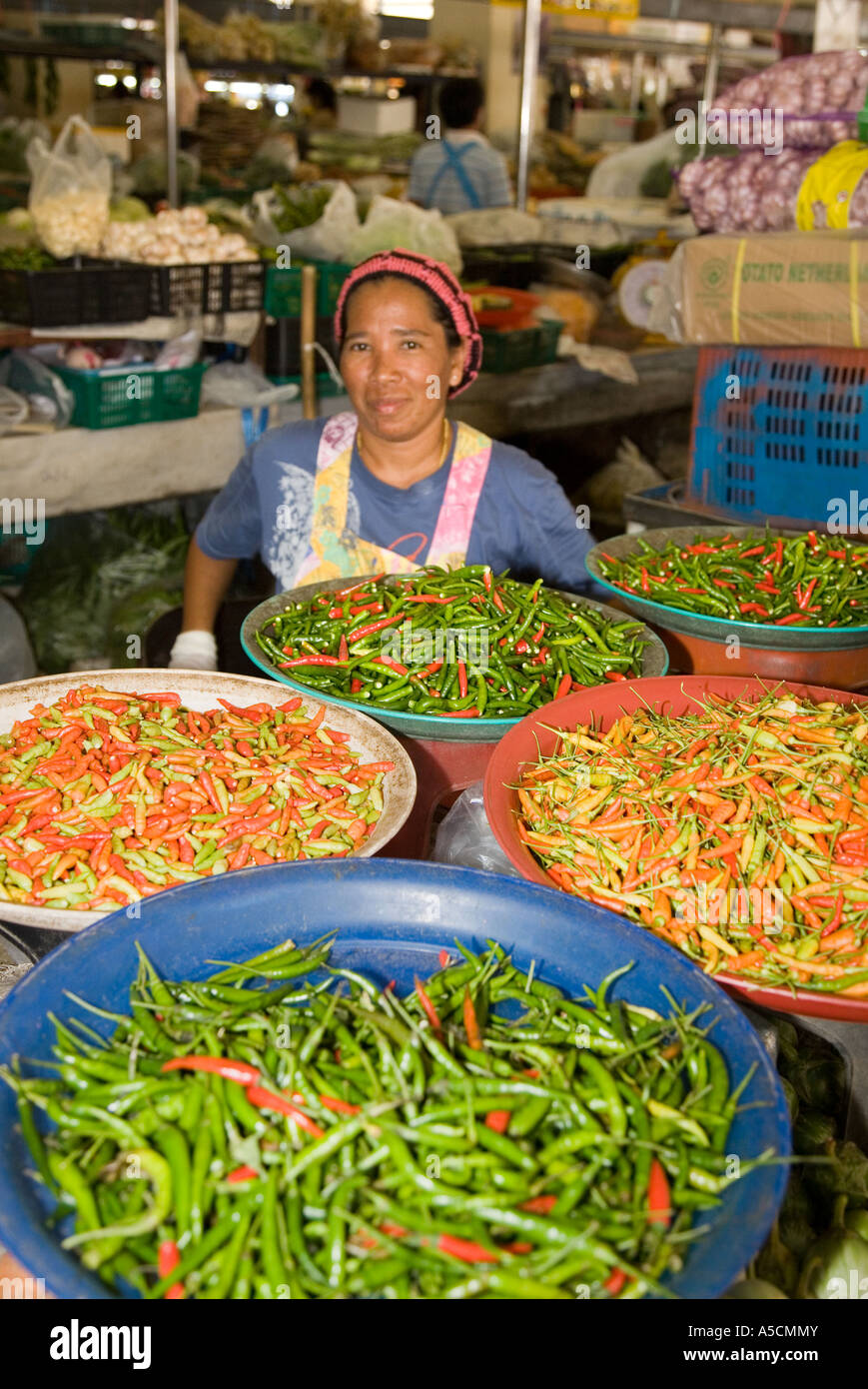 Frau, die Schüsseln mit einer Vielzahl von heißen scharfen Chilis, asiatische, asiatische Gemüsechilli, traditionellen Indoor Food Market, Provinz Krabi, Thailand verkauft Stockfoto