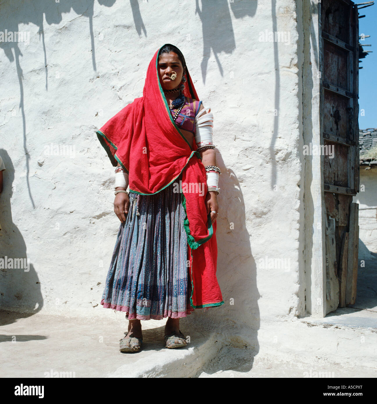 Eine Rajasthani-Frau in bunten Trachten und tragen elfenbeine Armreifen, die Reichtum, Thar-Wüste, Rajasthan, Indien bezeichnen Stockfoto