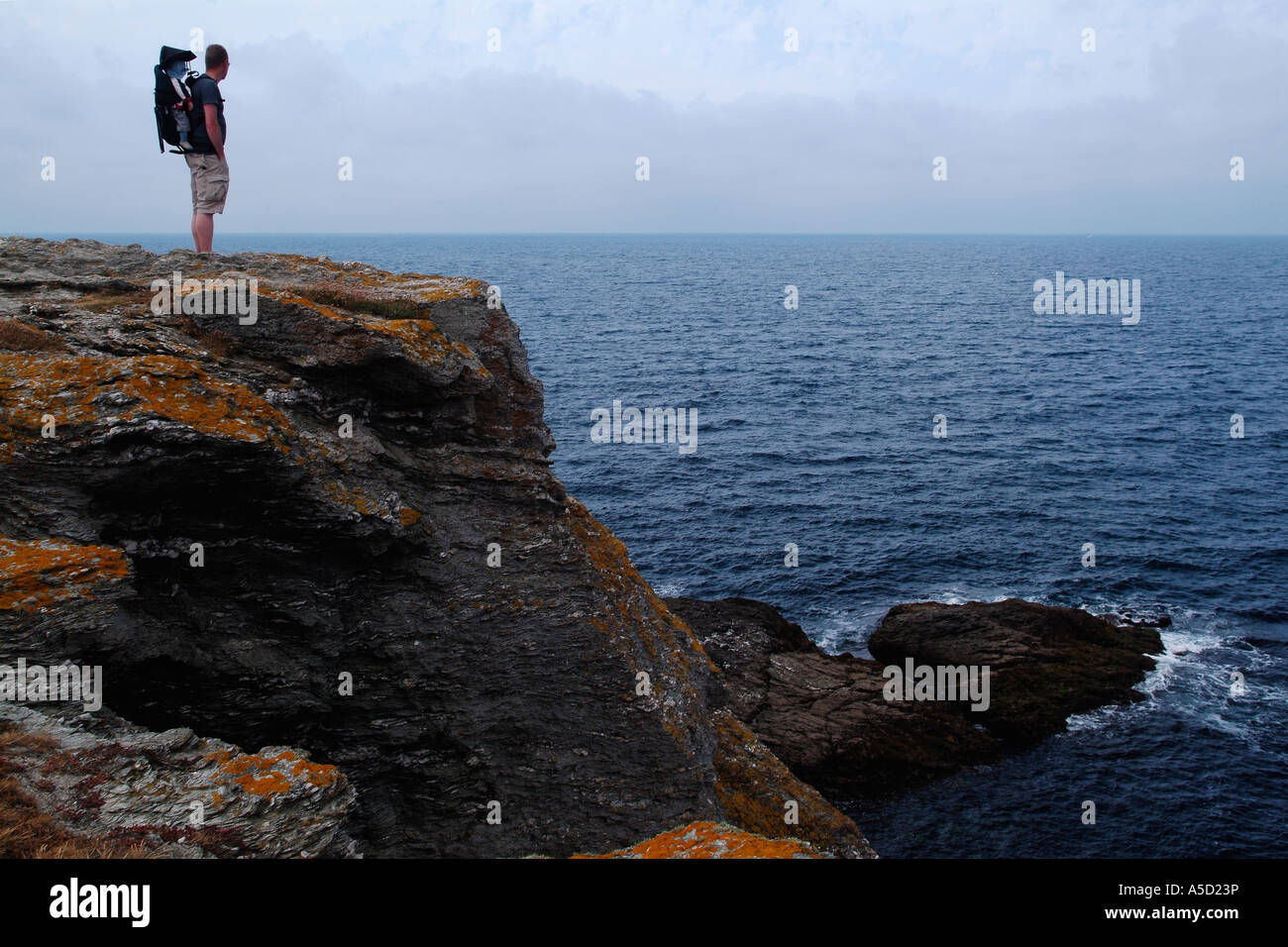 Mann und sein Baby suchen den Ozean von einer Klippe in Belle-Ile Stockfoto