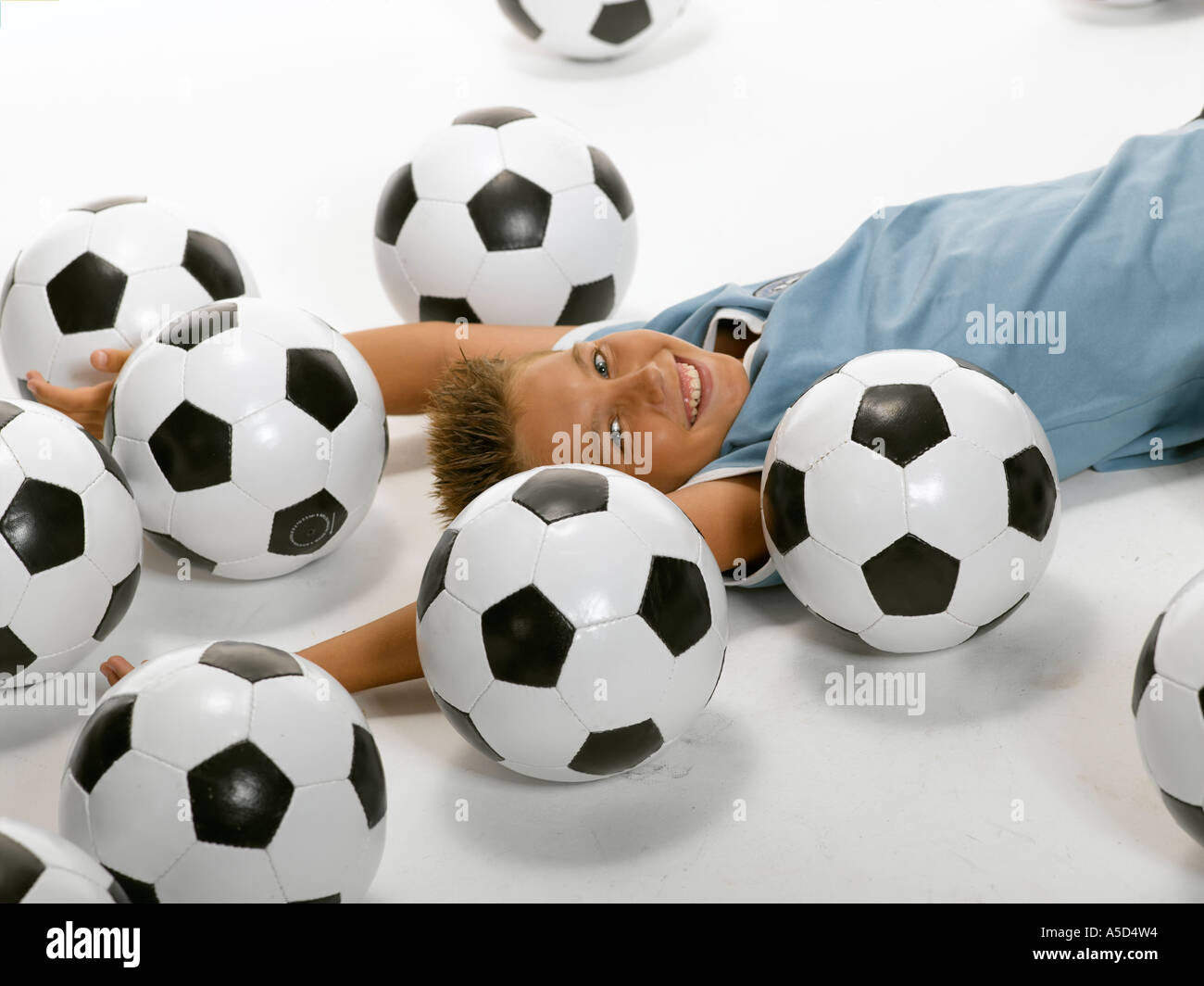 Junge (10-13) liegen zwischen Fußball Stockfoto