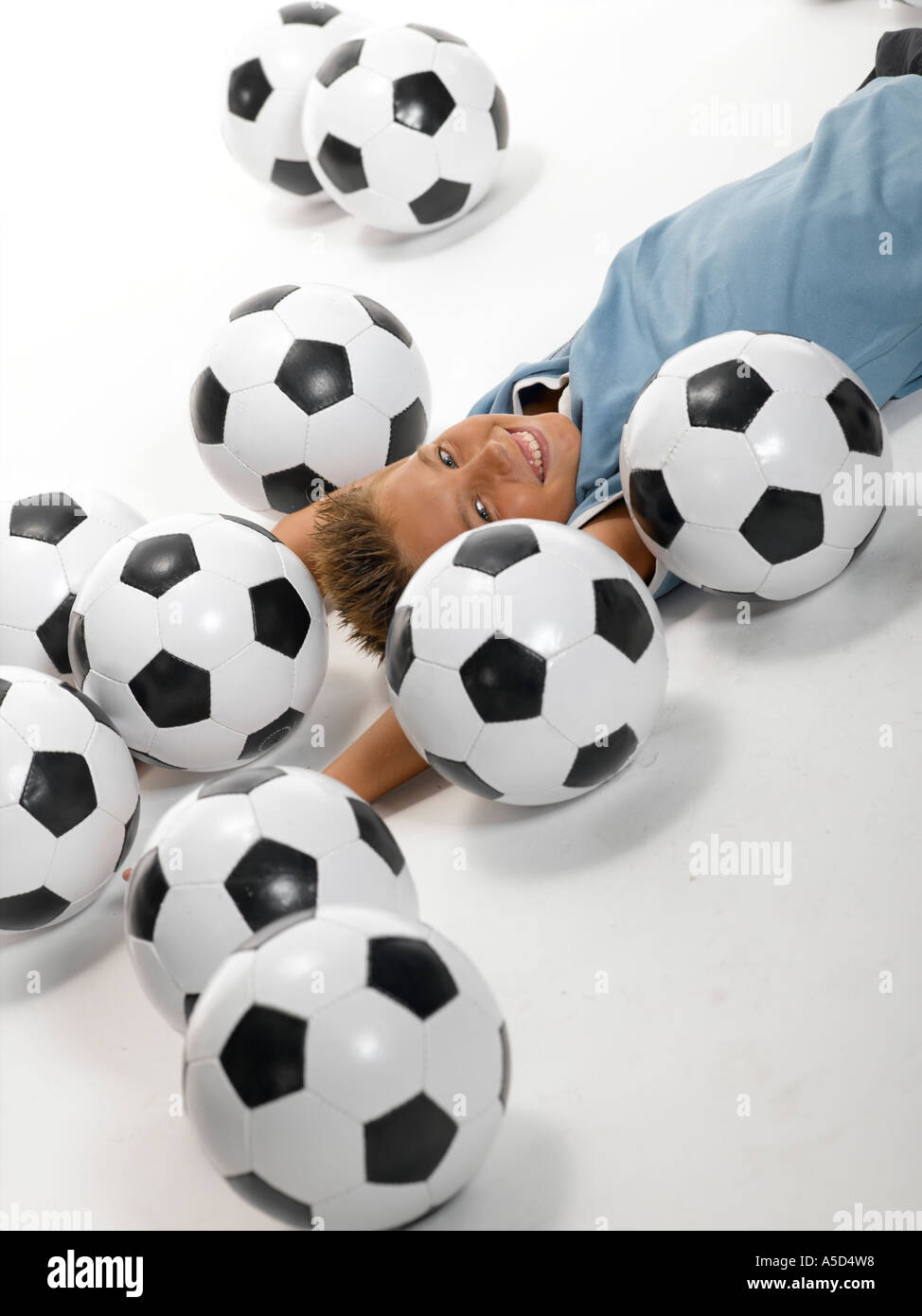 Junge (10-13) liegen zwischen Fußball Stockfoto