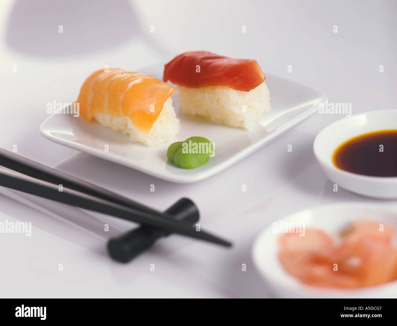 Sushi auf Teller mit Stäbchen Stockfoto