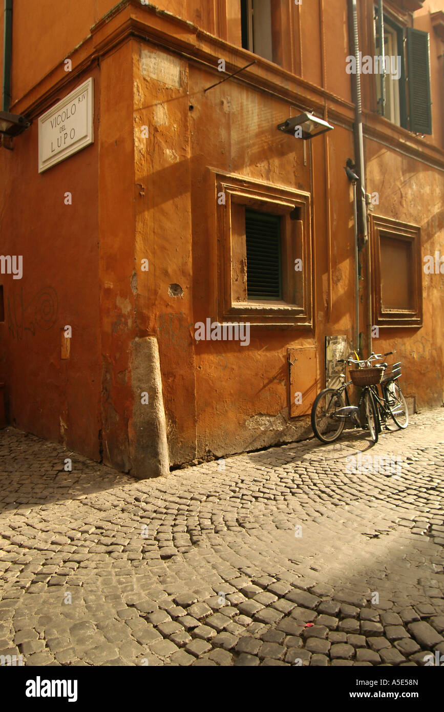 Rom Italien Fahrräder eine orange Wand in einer Gasse in Rom Kopfsteinpflaster gelehnt Stockfoto