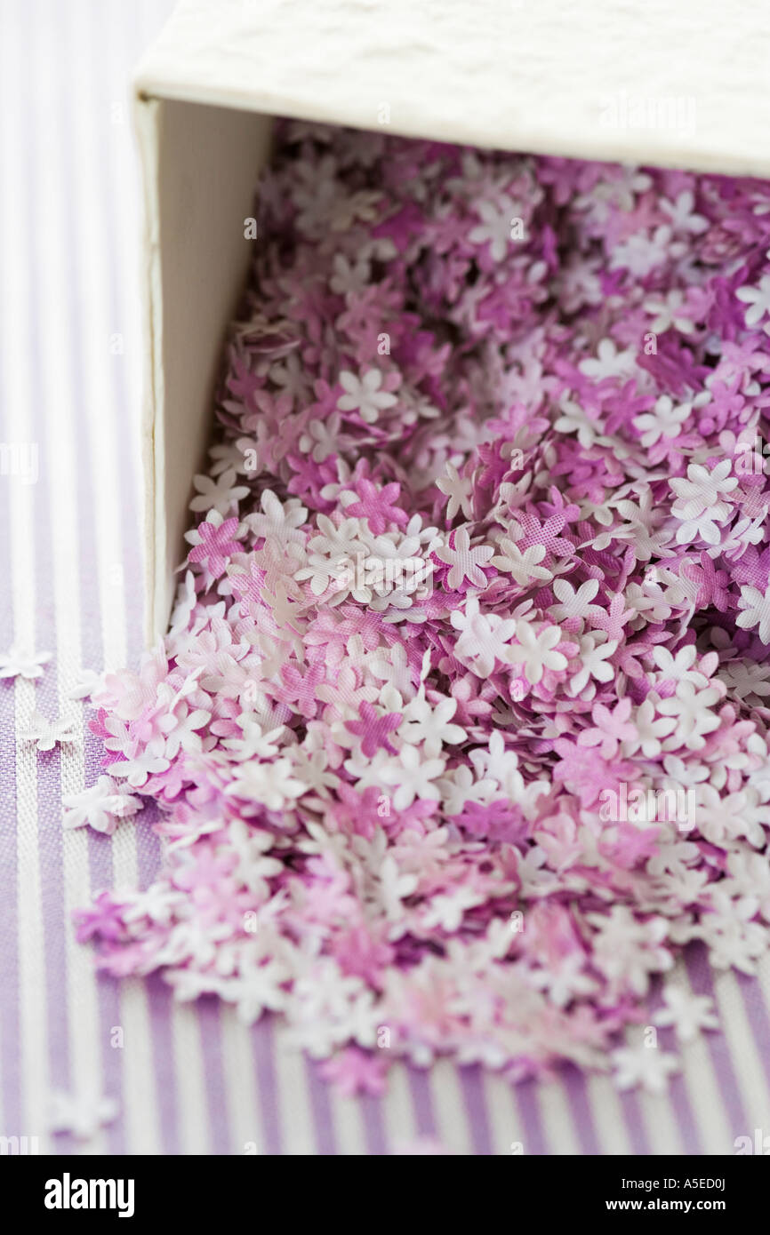 Miniatur-Textilblumen fallen aus einer box Stockfoto
