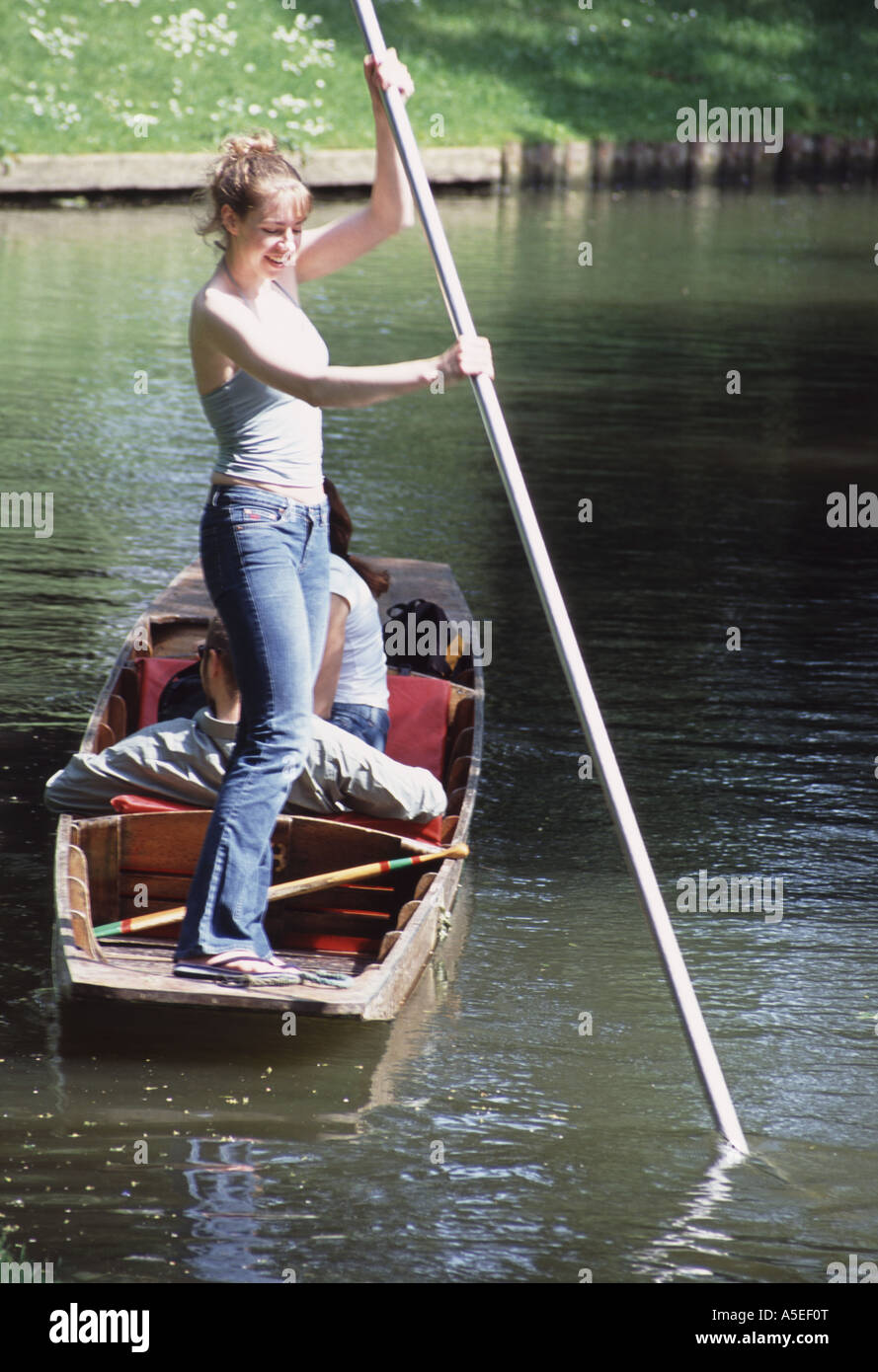 Lächelnde junge Frau lernen, punt, antreiben ihr Boot durch Drücken auf ein Pole, Fluss Cherwell, Oxford, UK Stockfoto