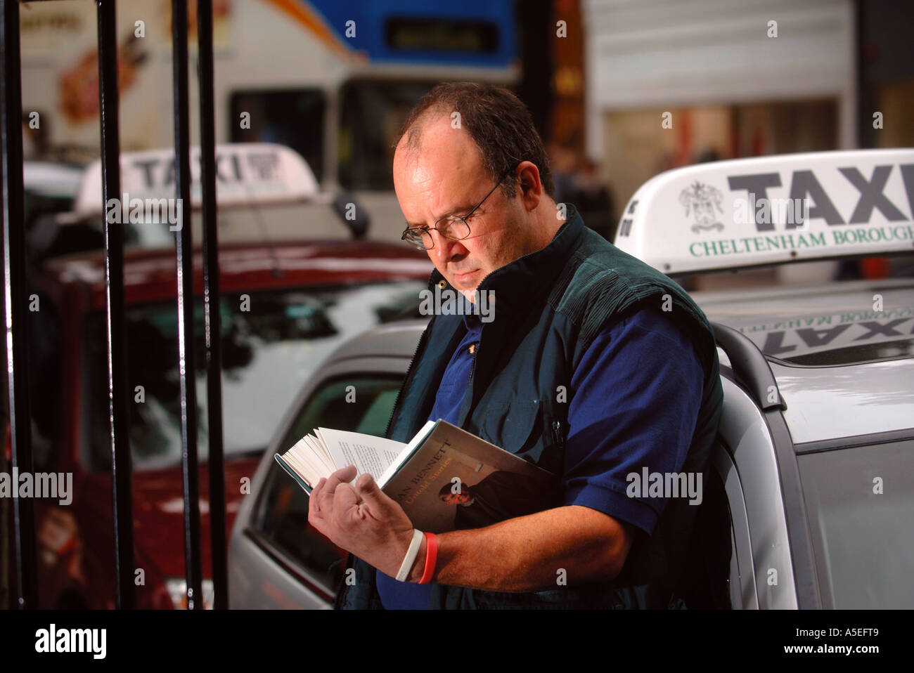 EIN TAXIFAHRER LESEN UNTOLD STORIES VON ALAN BENNETT ALS BESTANDTEIL DES BUCH DROP SCHEMA BEI DER CHELTENHAM LITERARISCHE FESTIVAL UK Stockfoto