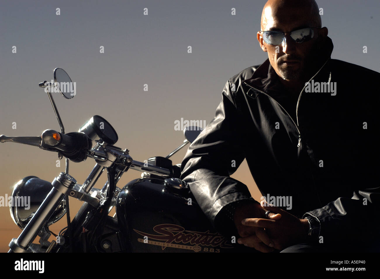 Porträt des Mannes mit Lederjacke und Sonnenbrillen sitzen auf Harley Motorrad Stockfoto