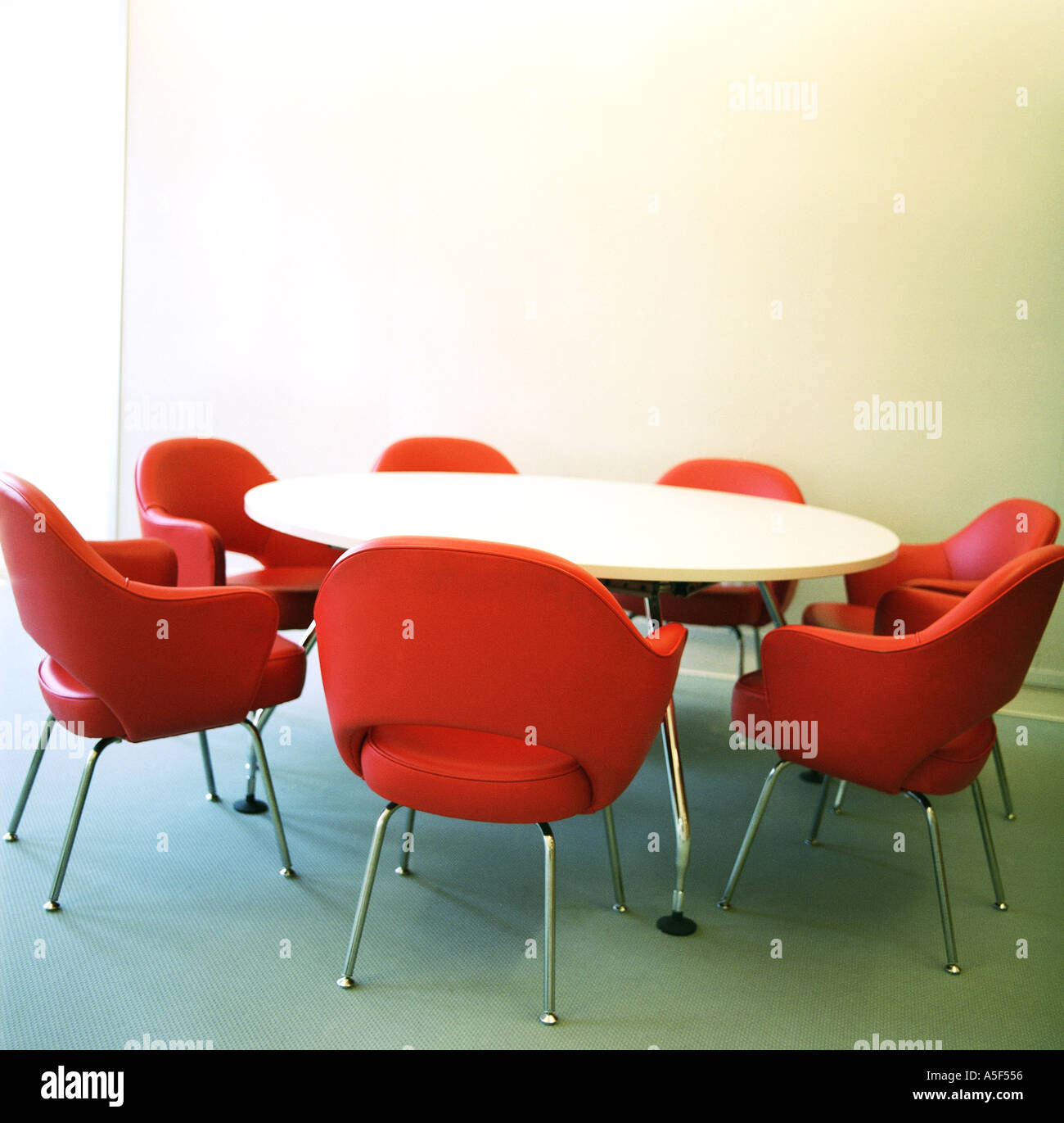 Rote Stühle um einen runden Tisch Stockfoto