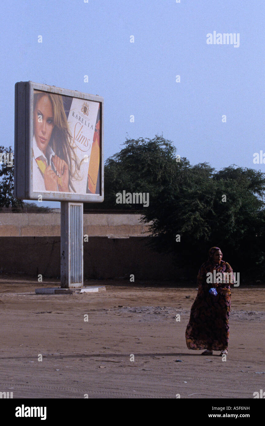 Eine Frau auf der Straße vor der Zigarette Werbung, Nouakchott Mauretanien, Afrika Stockfoto