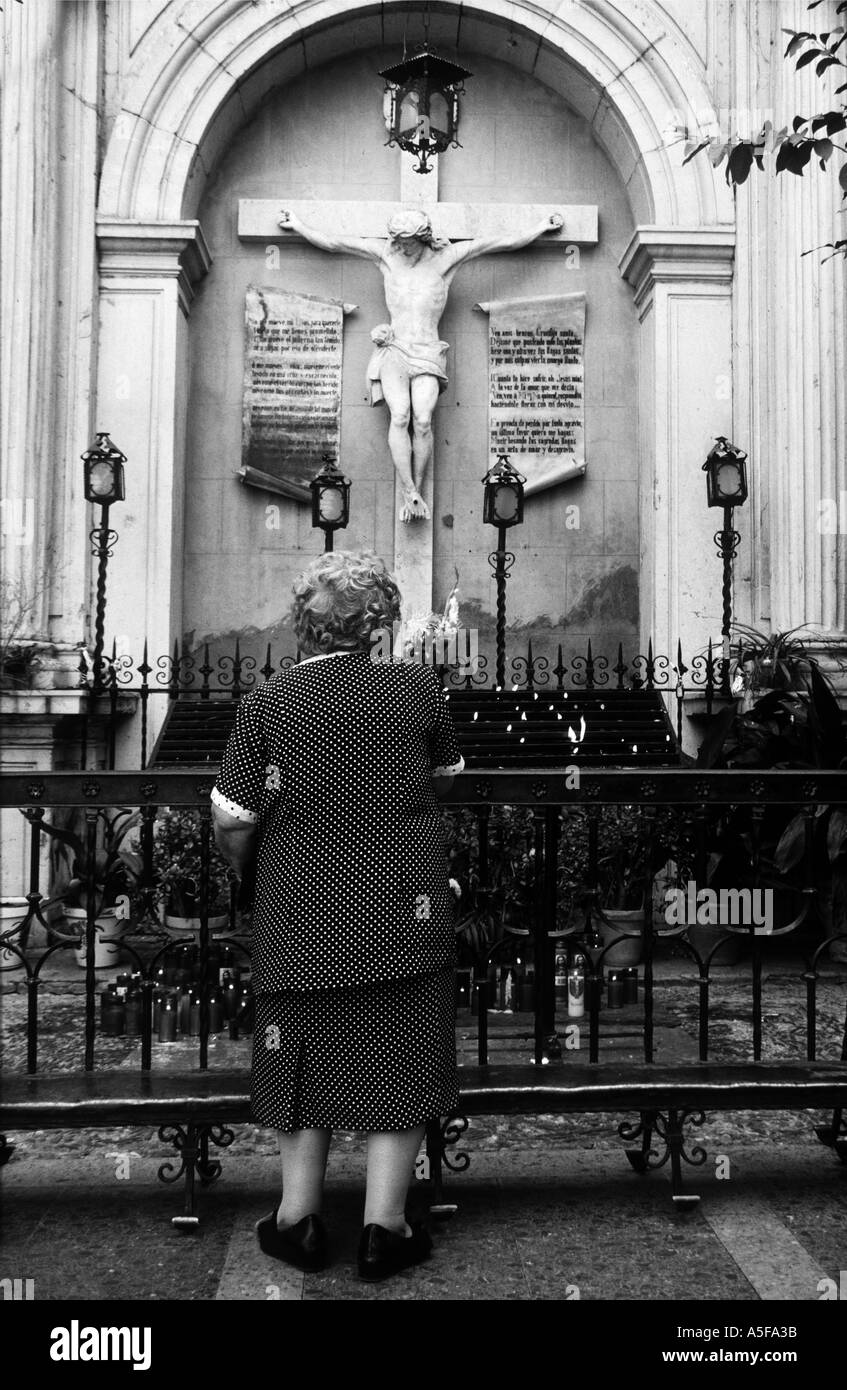 Frau beten am Kruzifix in Spanien Stockfoto