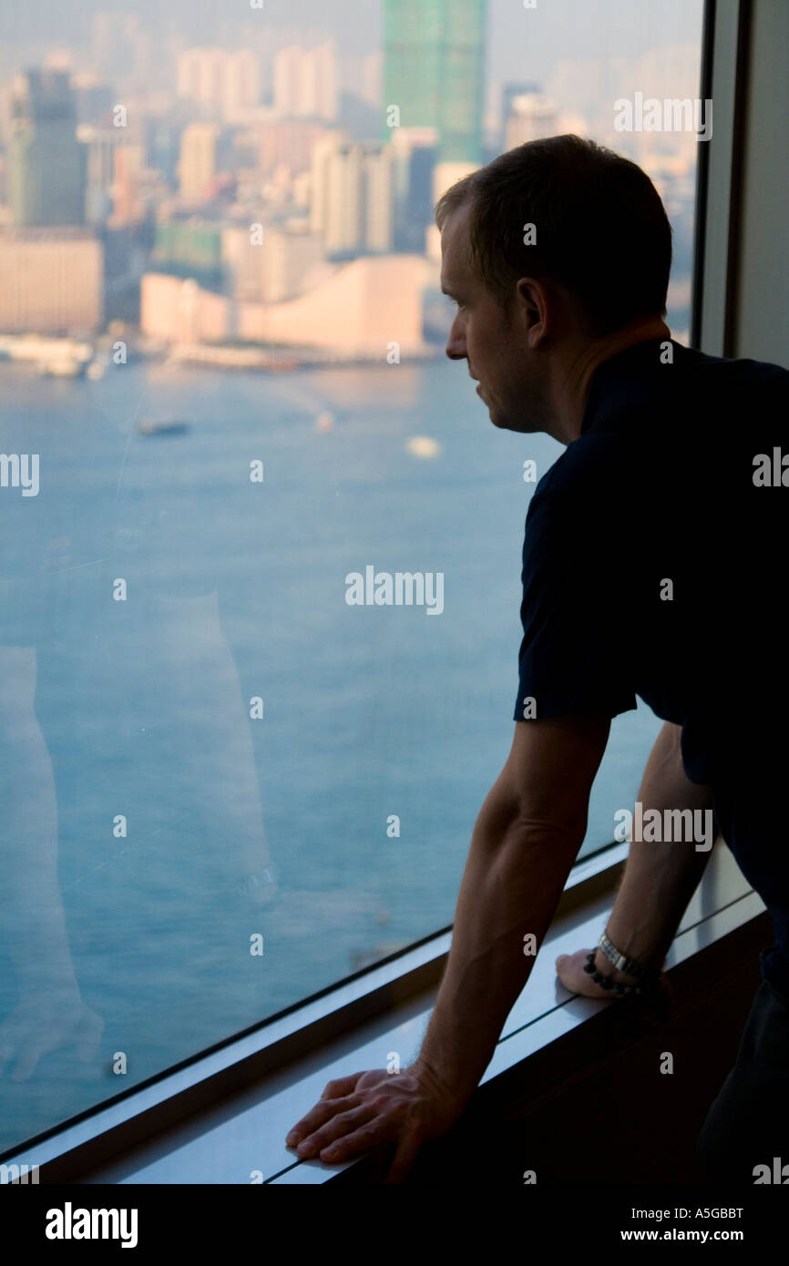 Mann auf der Suche die Hong Kong Skyline von einem hohen Gebäude Stockfoto