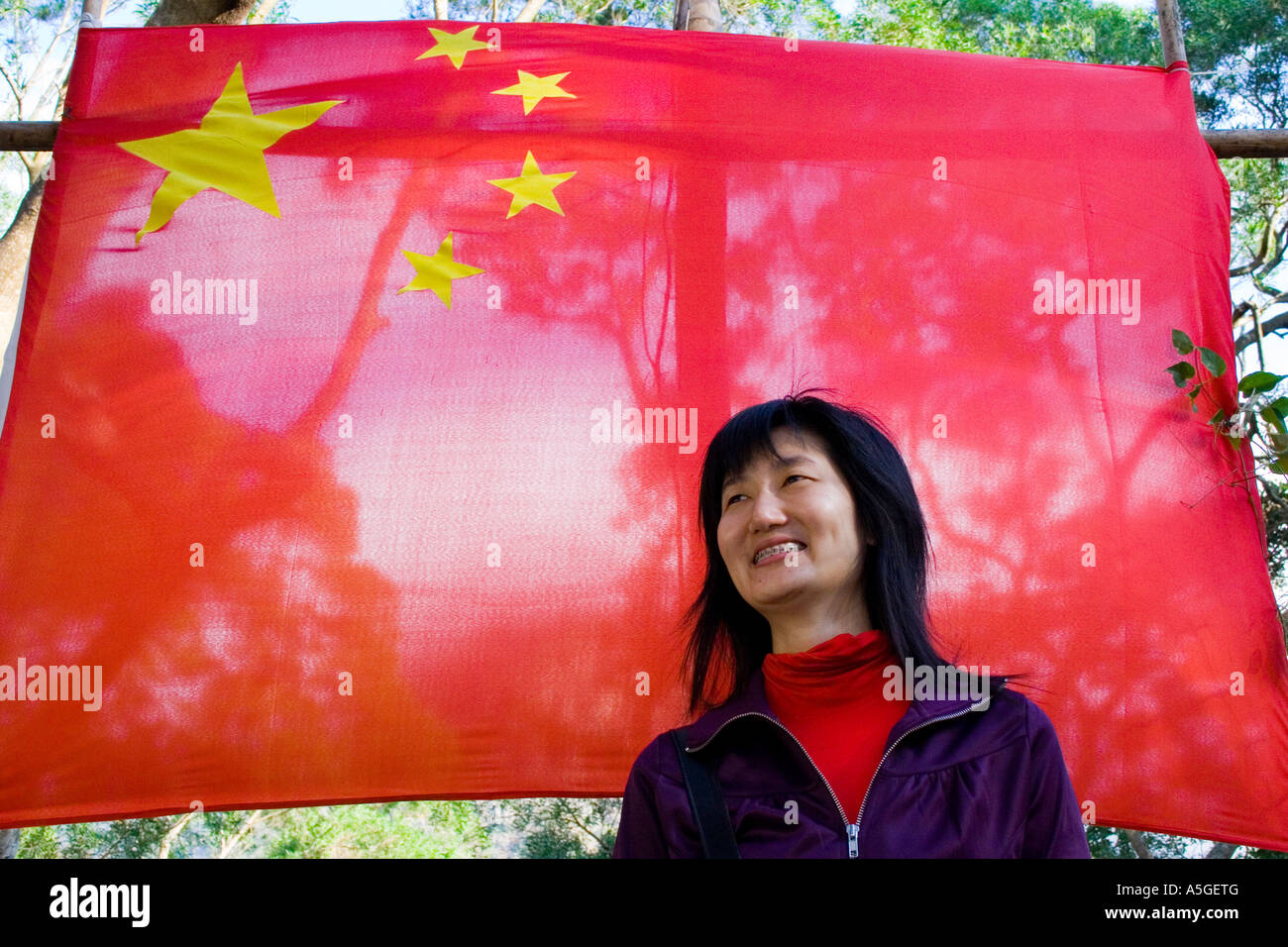 Hochgewachsene junge schöne chinesische Frau Partei Mitglied VR China Flagge Stockfoto