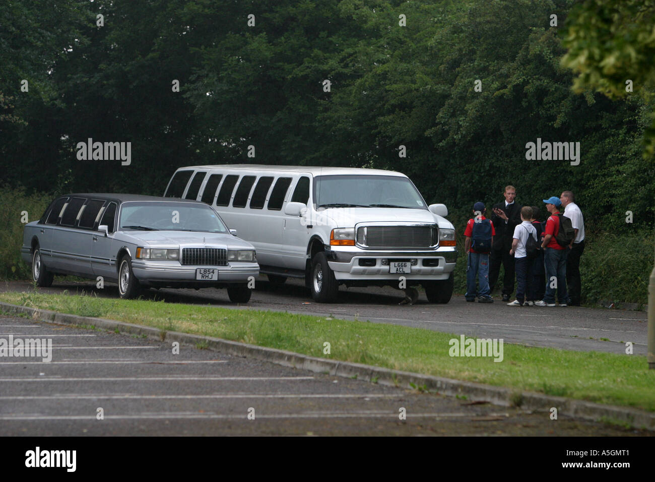 Limousinen für Jugendliche außerhalb ihrer Schule Abschlussball warten Stockfoto
