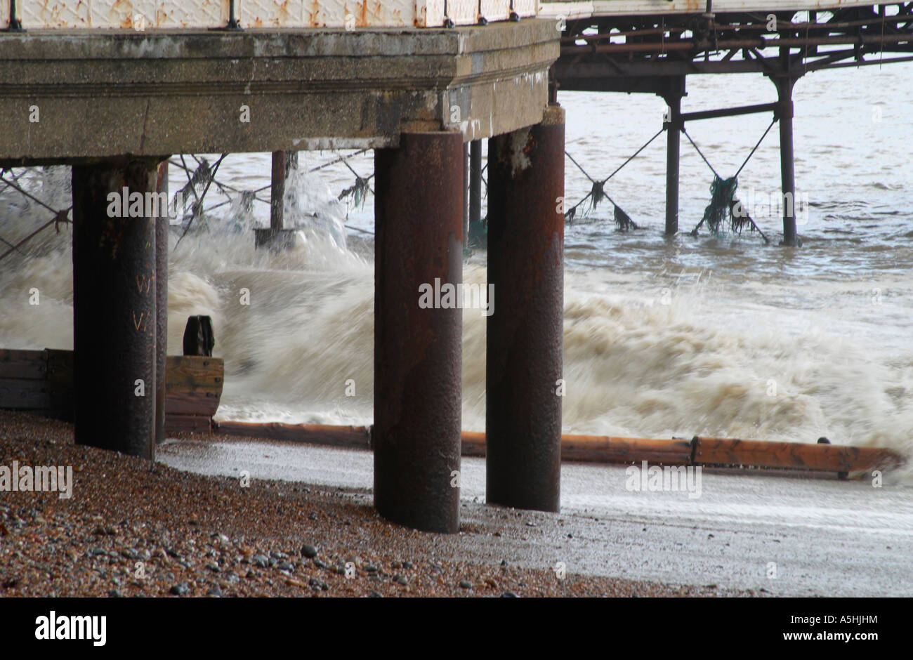 Wellen krachen bei Flut am Strand unter dem Pier. Worthing, West Sussex, Großbritannien Stockfoto