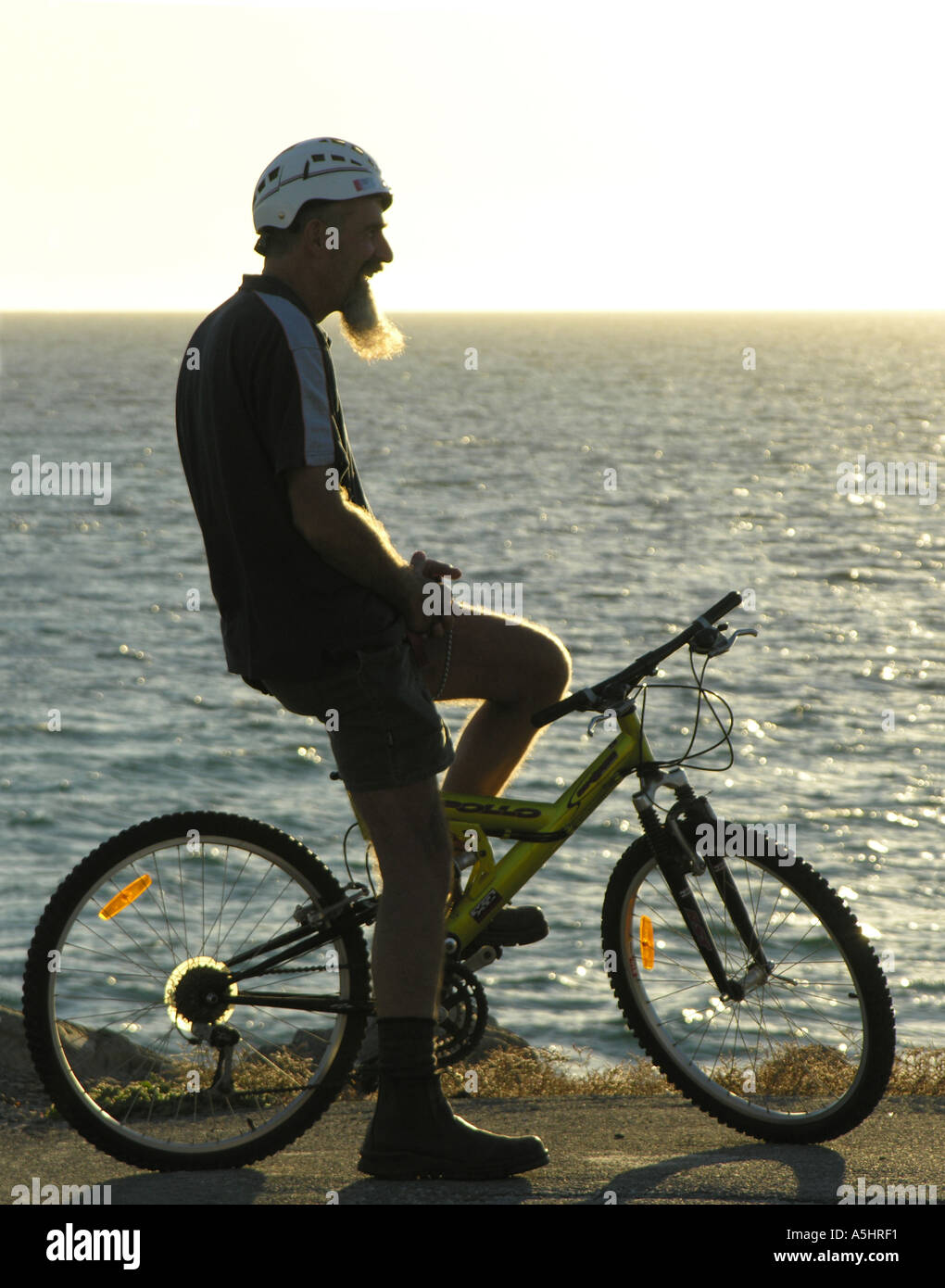 Lustiger Mann mit langen Goatie Bart sitzen auf dem Fahrrad vor Lachen Stockfoto
