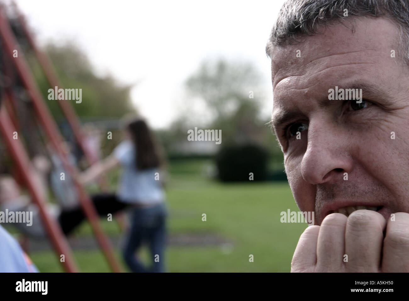 Applying Mann in nachdenklicher Pose mit Hand am Kinn im Park in Leicester England Stockfoto