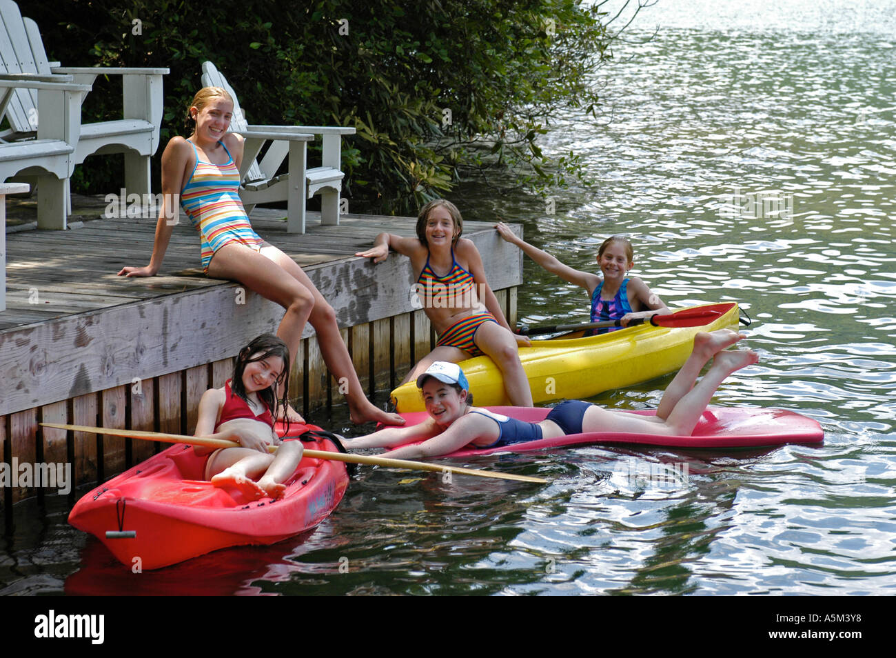 Eine Gruppe von Mädchen versammelt eine Bootsanlegestelle am Lake Rabun Georgien auf Flößen und in Kajaks Stockfoto