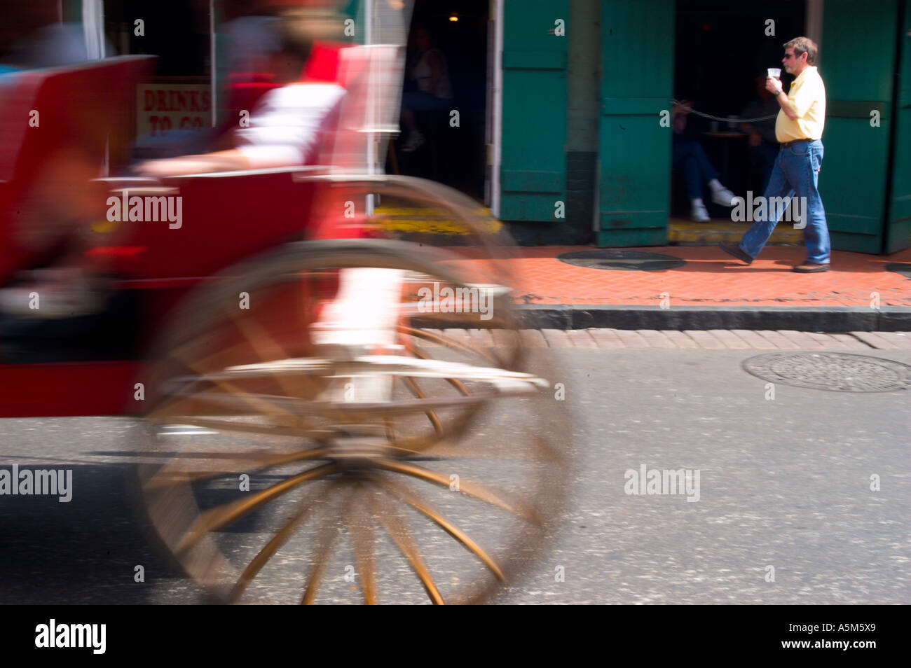 Die Räder von Pferd und Buggy Kutsche drehen in einen Strudel von Bewegung, als es auf einer alten Straße im French Quarter in New Orleans Louisiana reitet Stockfoto