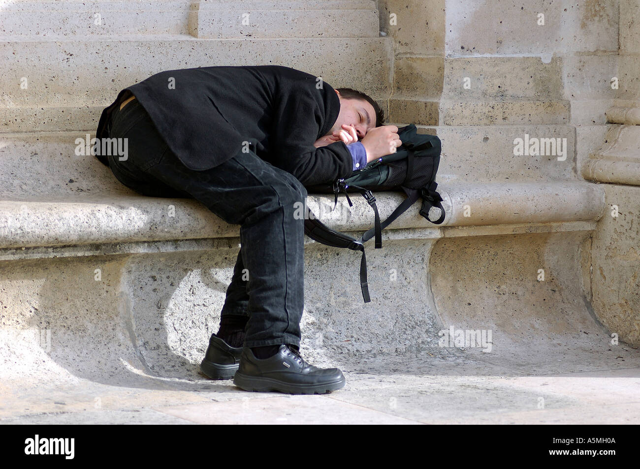 Mann schläft auf einer Bank in einer lustigen ungewöhnliche humorvolle Haltung Haltung Paris Frankreich Europa Stockfoto