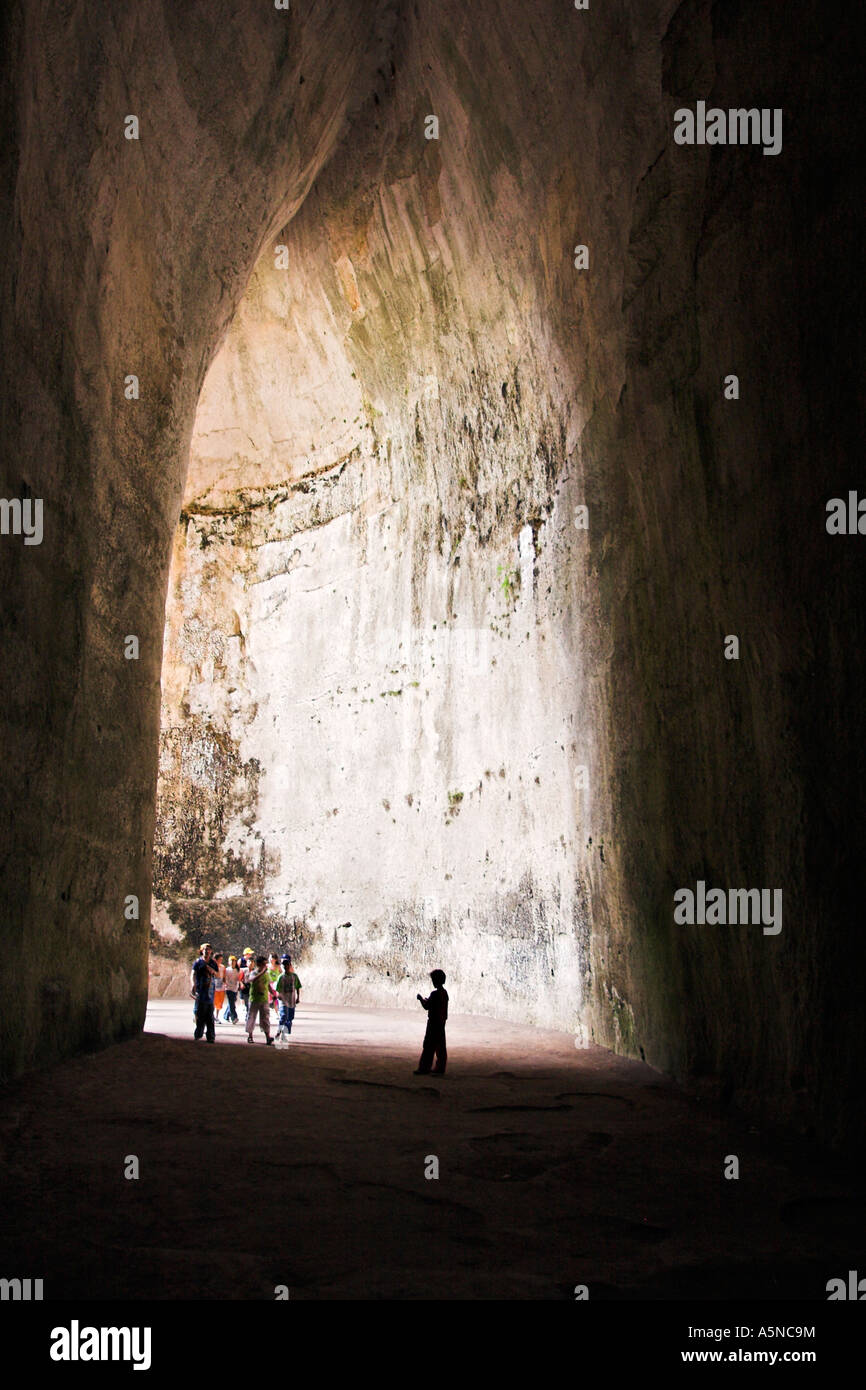 Testen die Akustik: eine kleine Laute Schulgruppe betritt die Teardrop-geformte Höhle bekannt als das Ohr des Dionysius Stockfoto