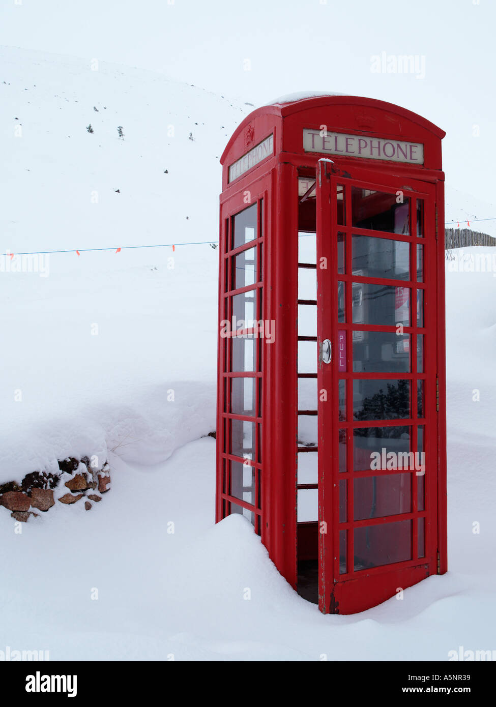 Alten altmodischen rotes Telefon Box K6 mit Tür zu öffnen, im tiefen Winterschnee auf Cairngorm Berg Cairn Gorm Highland Scotland UK Stockfoto