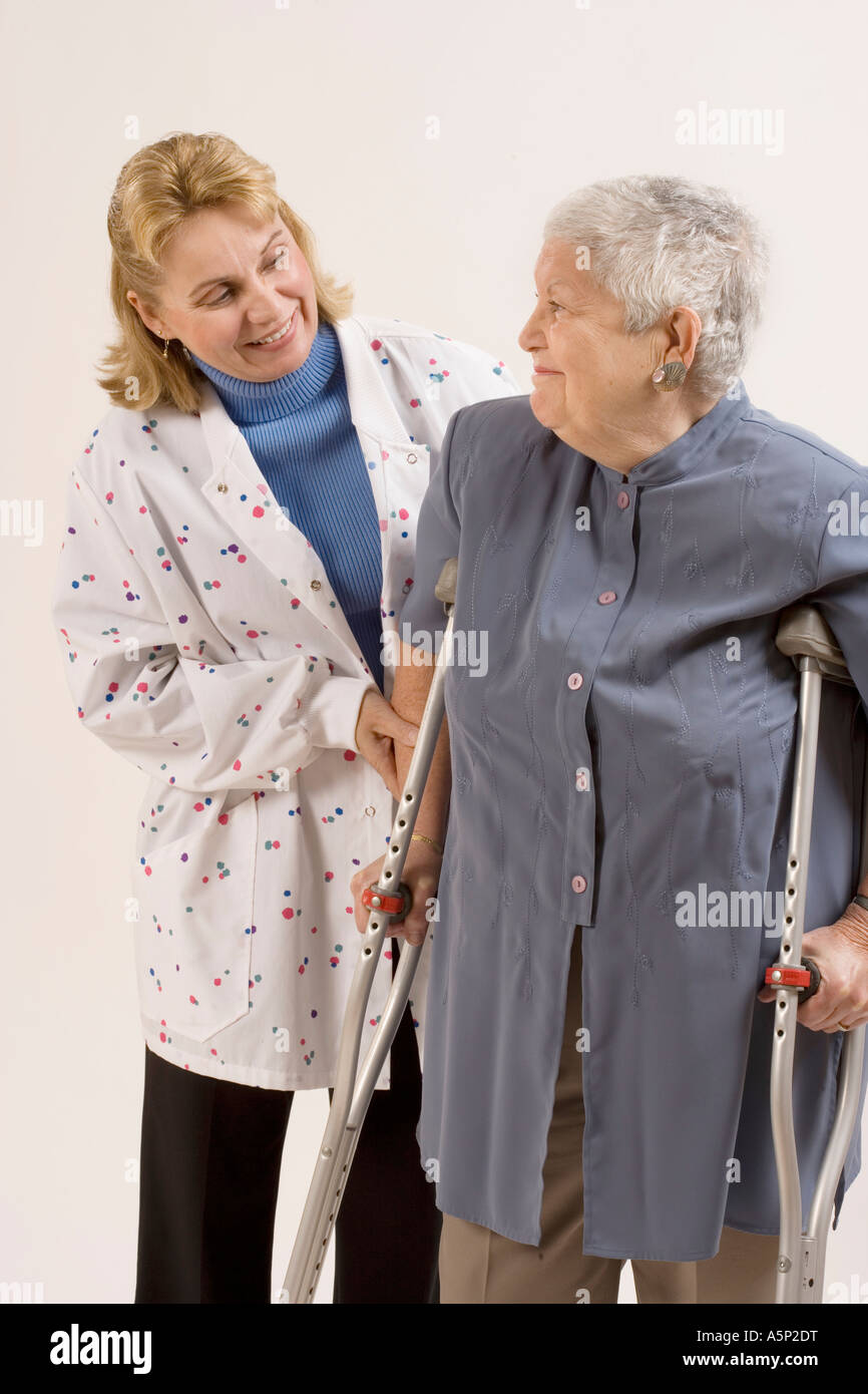 Home health care Besuch Krankenschwester hilft Patientin mit Krücken. Stockfoto