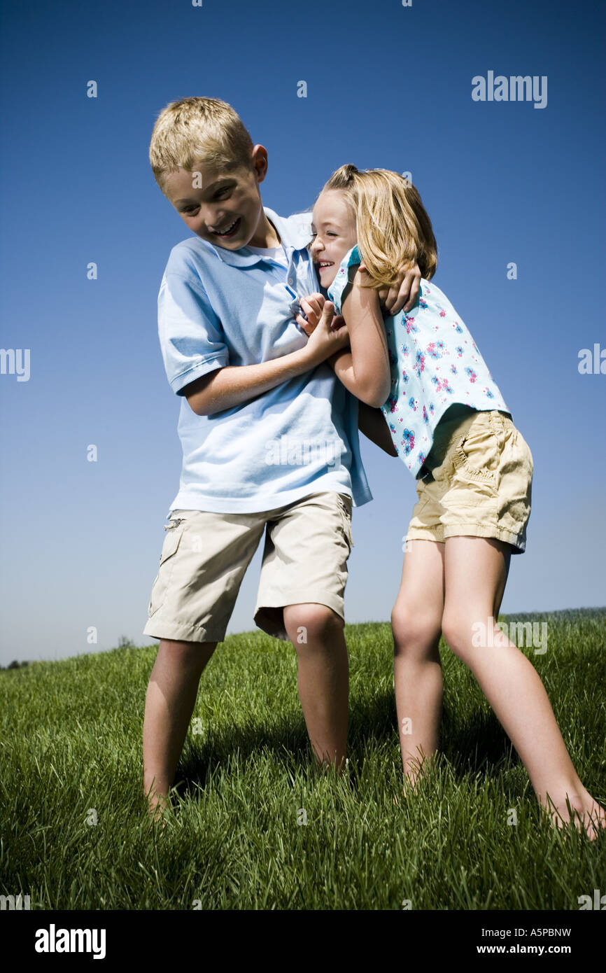 Jungen und Mädchen spielen auf einem Hügel Stockfoto