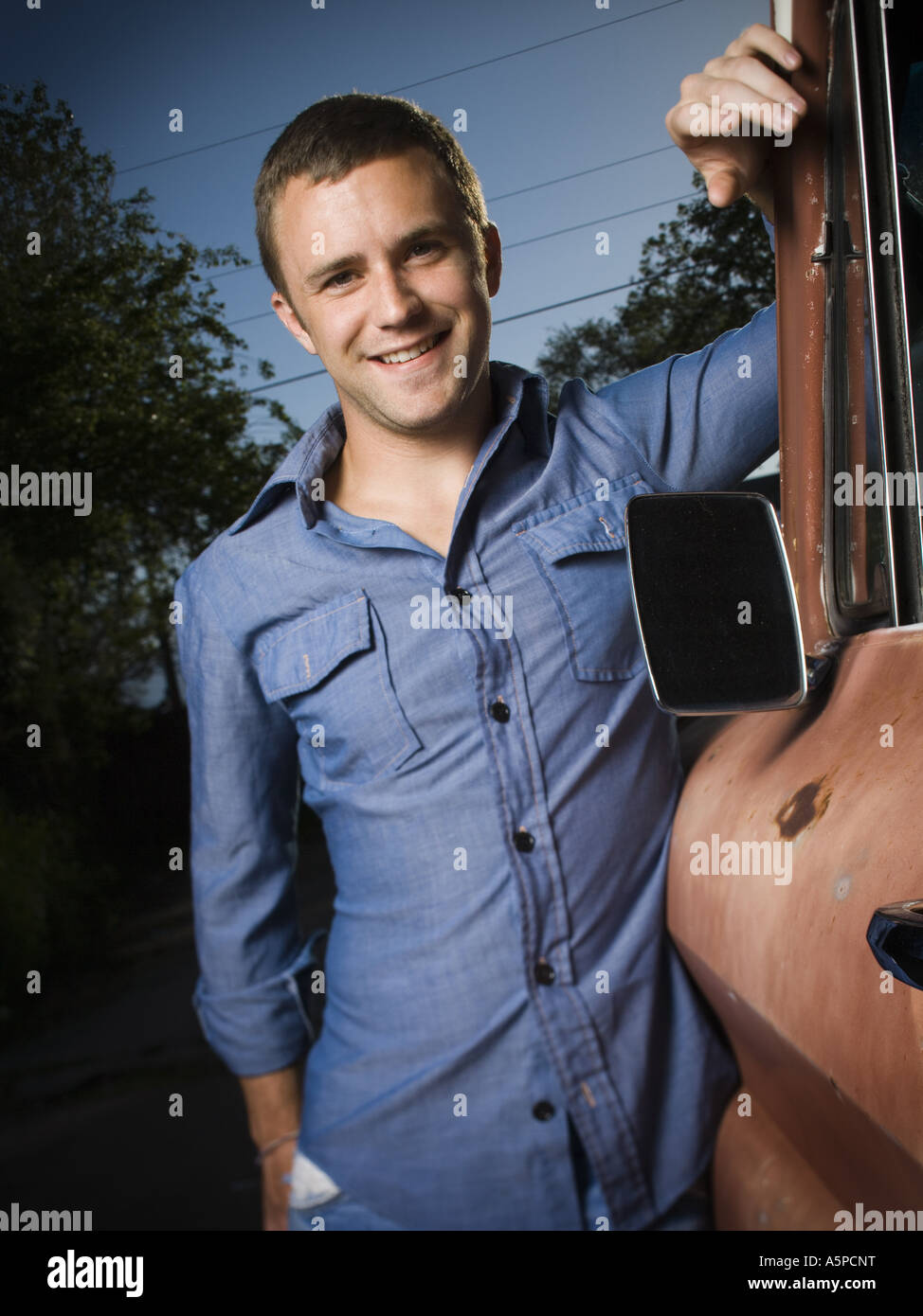 Lächelnder Mann stehend neben alten LKW Stockfoto