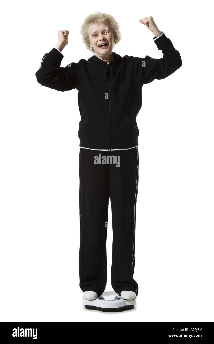 Ältere Frau mit einem Gewicht von selbst auf eine Personenwaage Stockfoto