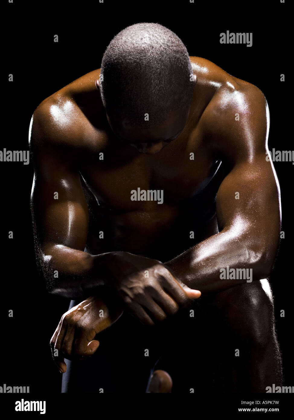 Muskulöse Sportler im dunklen Raum Stockfoto