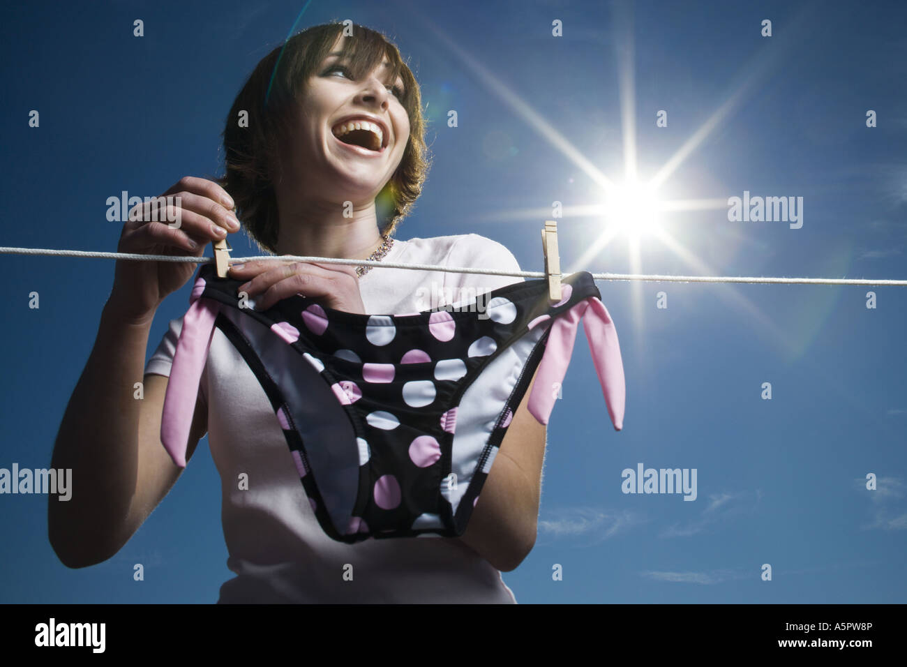 Niedrigen Winkel Ansicht eines Mädchens ein Bikiniunterteil auf einer Wäscheleine trocknen Stockfoto