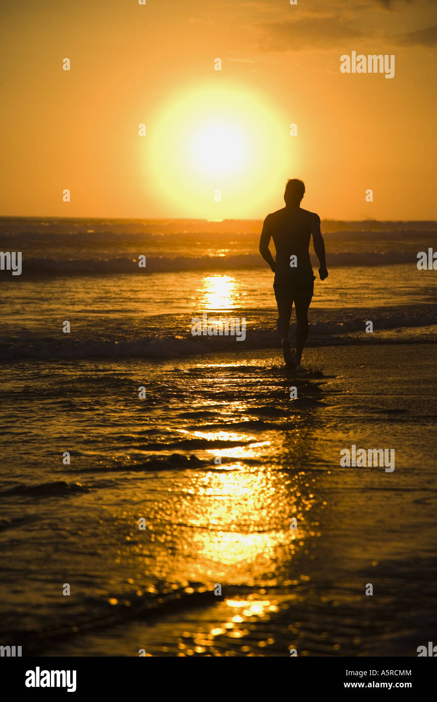 Silhouette einer Person zu Fuß am Strand Stockfoto